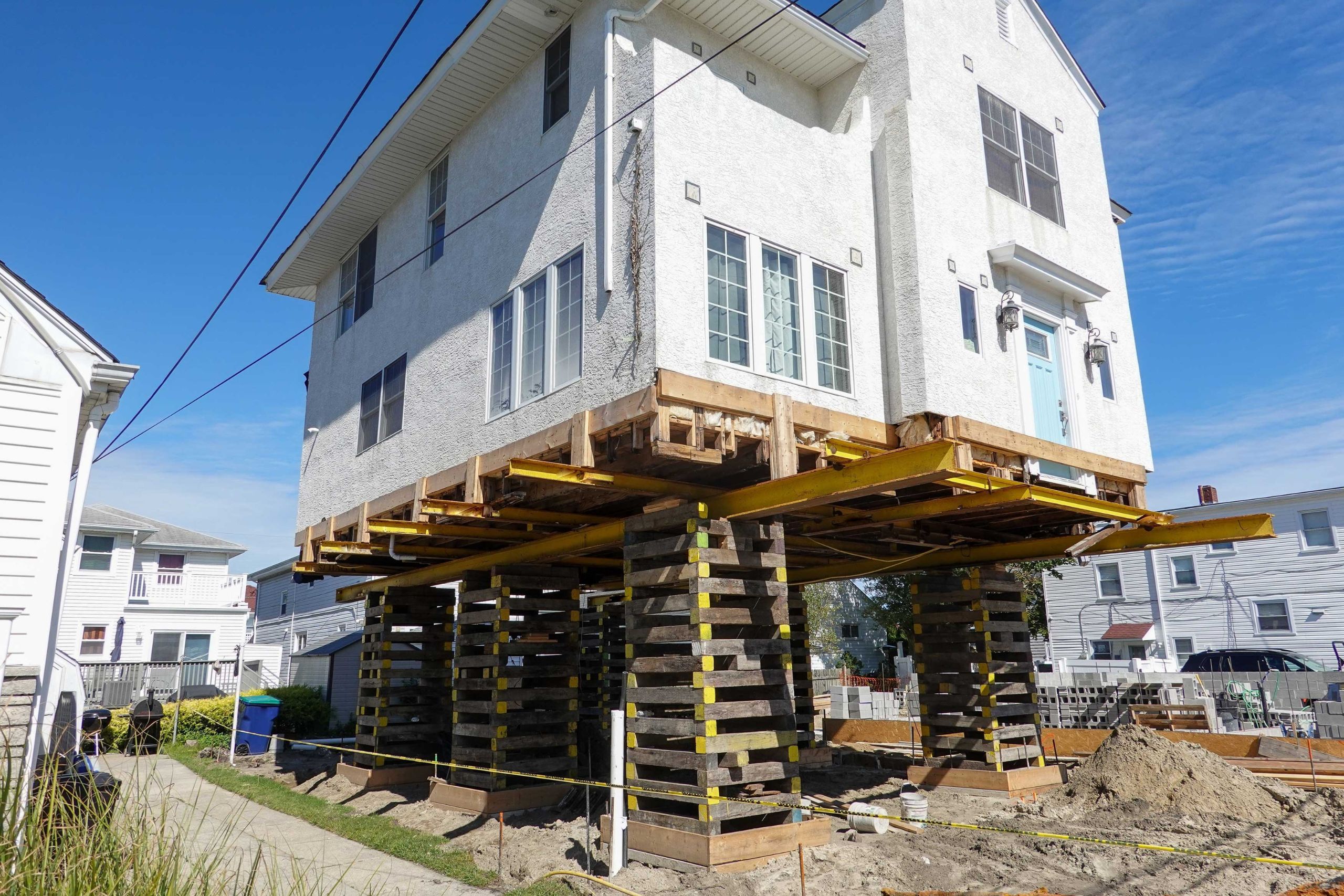 A team of professionals using specialized equipment to raise a house in Fort Myers, preparing it for elevation and renovation